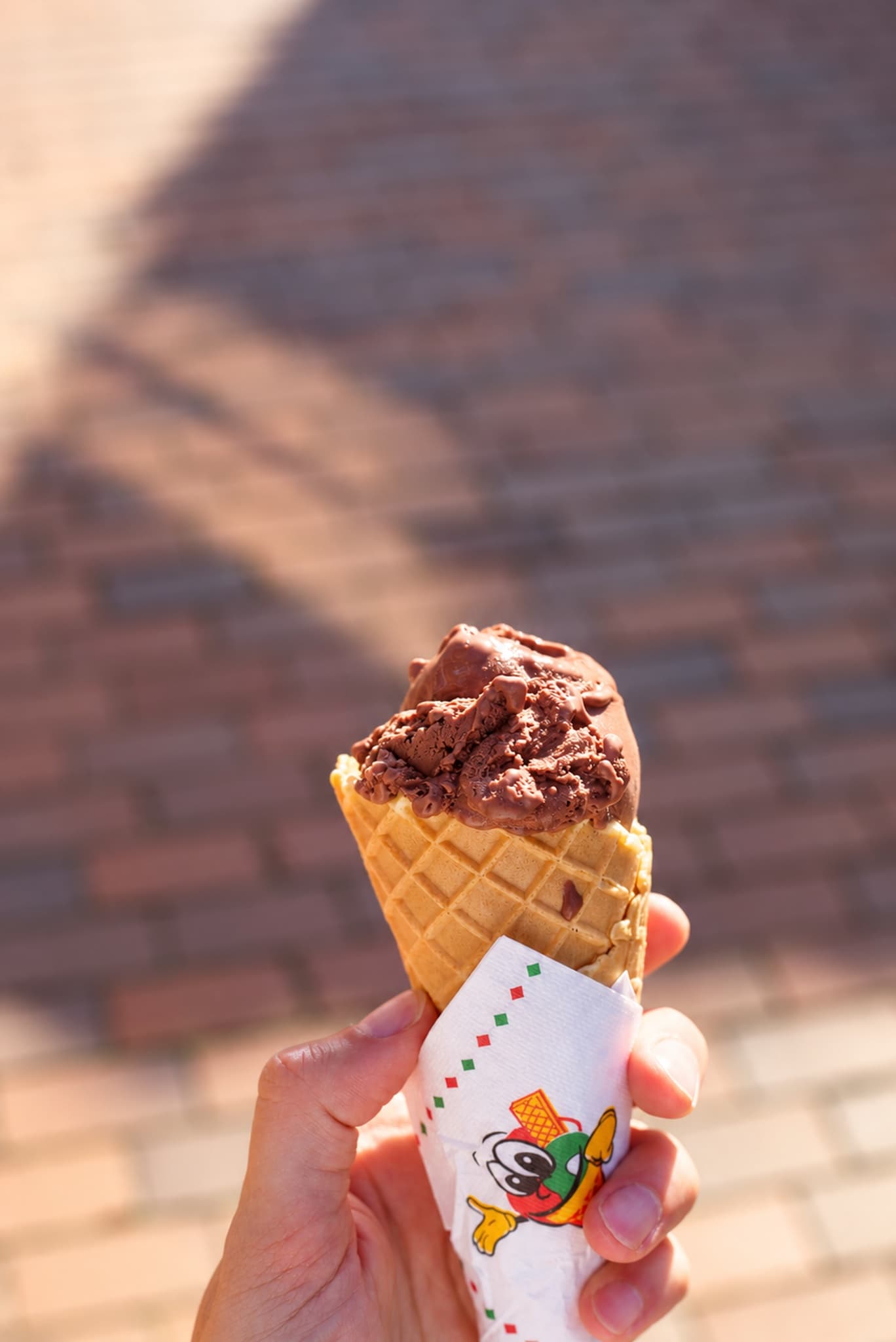 Schokoladen-Gelato in der Waffel, in der Hand gehalten