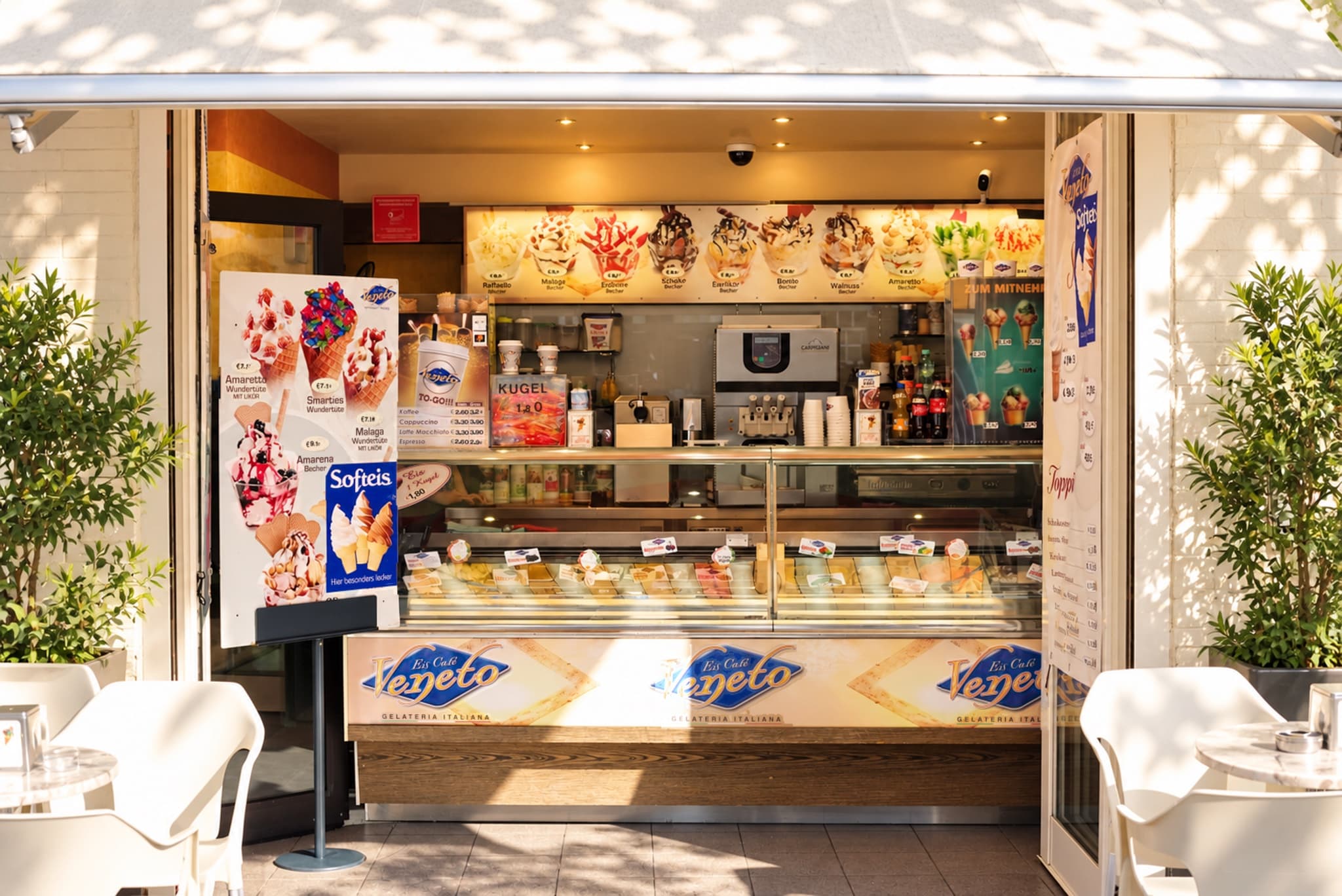 Eiscafé Veneto am Hafen — die zur Straße offene Eistheke mit Vitrine und Veneto-Schriftzug, davor weiße Stühle
